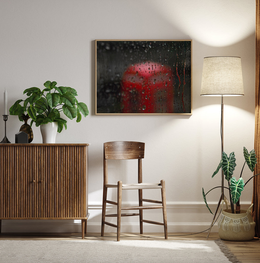 Rainy window with a blurred red postbox visible in the background, creating a moody and nostalgic atmosphere.